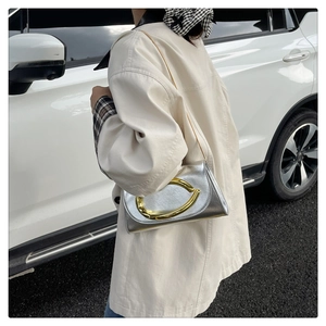 Détail du sac argenté métallisé avec fermoir fer à cheval doré et bandoulière chaîne