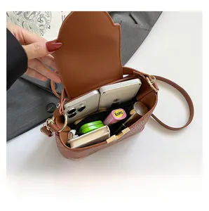 Internal view of brown woven crossbody bag showing large capacity for phones and makeup