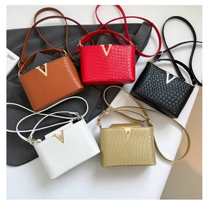 Top view of five woven leather mini bags in various colors with gold V-shaped metal hardware