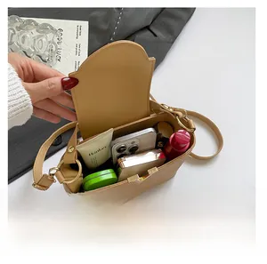 Binnenzicht van kaki crossbodytas met ruimte voor een telefoon en diverse cosmetica