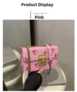 Pink cherry pattern crossbody bag detail with golden chain and metallic twist lock