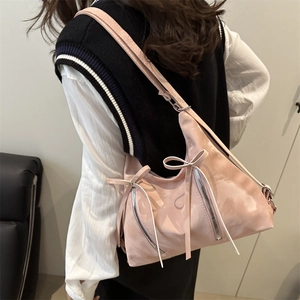 Sac fourre-tout rose à nœud papillon et zips métalliques porté par un mannequin