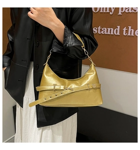 Detailed shot of golden metallic handbag featuring a stylish buckle strap and sleek chain