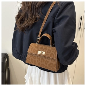 Detail view of brown leopard print crossbody bag with gold hardware and suede texture