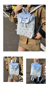 Detail of light blue bow and pearl pendant on a dotted print mini backpack for women