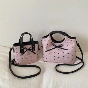 Pink quilted bucket bags with black bow patterns in mini and medium sizes on white fabric