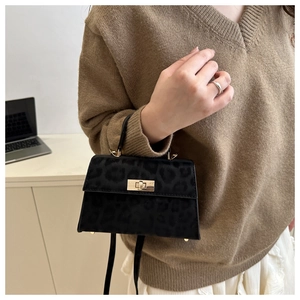 Detail of a black leopard print mini bag with metal twist lock and suede texture