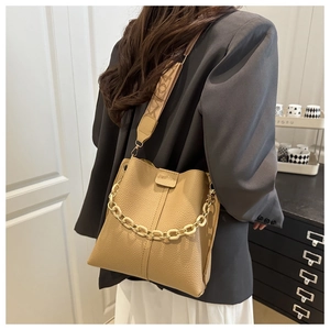 Detail of lychee pattern bucket bag with acrylic chain and monogram fabric strap
