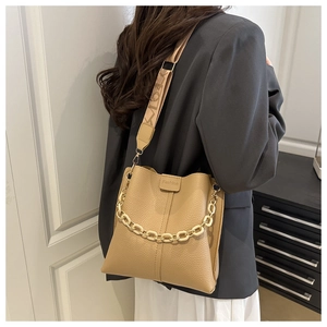 Detail of khaki bucket bag featuring lychee grain leather and decorative wide strap