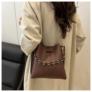 Detail showing deep brown lychee grain leather crossbody bag with chic fashion chain