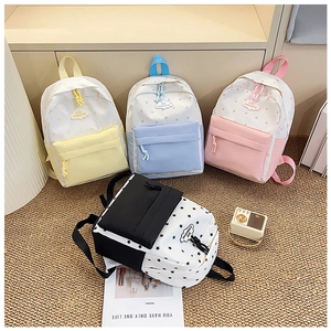 Détail de sacs à dos scolaires colorés en jaune bleu rose et avec motif étoilé