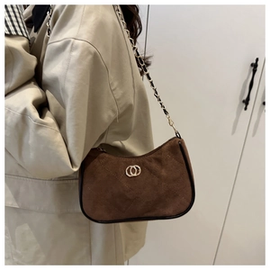 Detail of dark brown suede shoulder bag with quilted stitching and gold chain strap