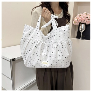 Detail of white polka dot tote bag with pleated ruffles and decorative bow handle