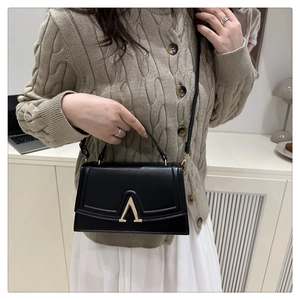 Vue détaillée du sac à bandoulière noir en similicuir avec boucle en métal doré en forme de V