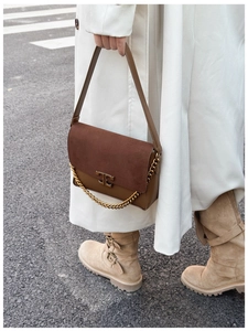Detail of brown leather and suede shoulder bag with gold chain and metal buckle
