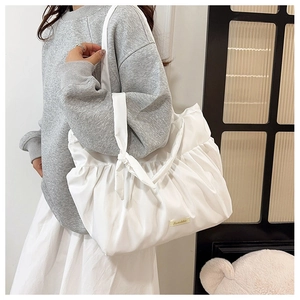 Detailed view of the large white pleated tote bag showing the soft ruffled fabric texture