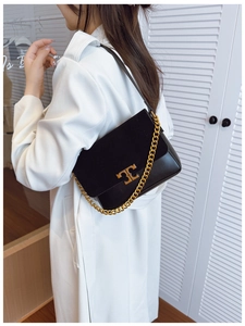 Detail view of the black leather and suede shoulder bag with gold chain and logo