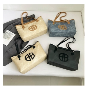 Multiple large capacity tote bags in varied colors featuring metallic B logo and straps