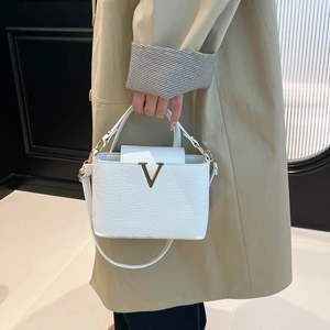 Elegante witte handtas met geweven textuur, gouden V-details en een schouderriem
