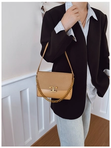 Detail of vintage khaki crossbody bag with gold T-clasp and metal chain strap