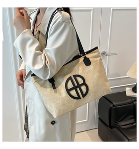 Détail du grand sac cabas avec bandoulières en cuir noir et empiècement logo circulaire chic