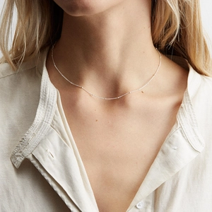 Minimalist silver stainless steel satellite chain necklace worn by a female model