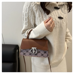 Detail of vintage crossbody bag with leather stitching and metal ring buckle closure