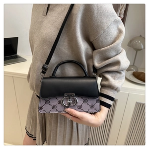 Detail of lavender patterned crossbody bag with metallic lock in a lifestyle setting