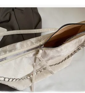 Detailed close-up of a smooth silver zipper and marble pleated texture on a beige tote bag
