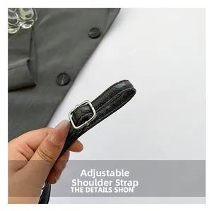 Detail of adjustable cracked leather shoulder strap with silver square metal buckle