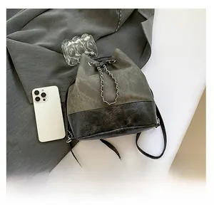 Detail of grey canvas and black vintage leather bucket bag with chain drawstring