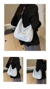 Macro view of beige tote bag showing crinkled leather texture and metal chain detail