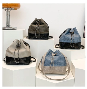 Multiple styles of bucket bags with chain details displayed on geometric blocks
