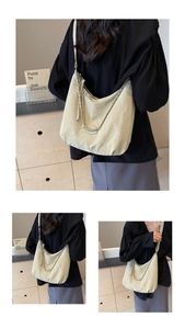 Detail of beige hobo bag with pleated texture and stylish silver chain strap
