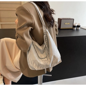 Detail of silver hobo bag with pleated texture and stylish metal chain strap