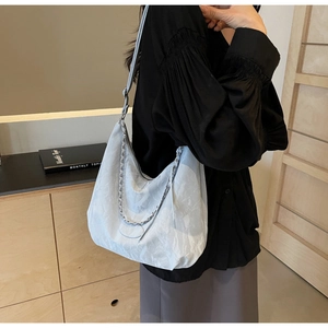 Detail of light blue pleated PU hobo bag featuring silver chain and textured material