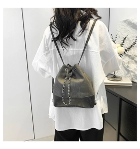 Detailed view of grey and black retro bucket backpack with metal chain drawstring