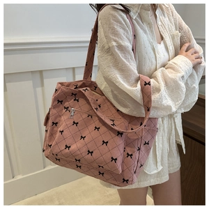 Detail of pink corduroy tote bag with bow print, diamond quilting and zip pocket