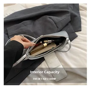 Capacité interne du grand sac hobo argenté montrant l'espace pour téléphone et maquillage