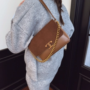 Brown vintage leather shoulder bag with suede flap and gold metal T logo on the front