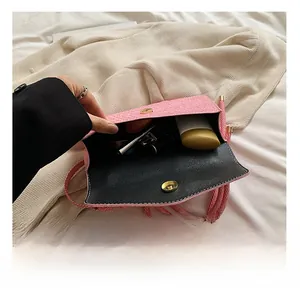 Pink woven crossbody bag detail showing interior capacity with lipstick and makeup