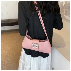 Gros plan sur un sac sous le bras en PU rose avec un détail papillon en paillettes