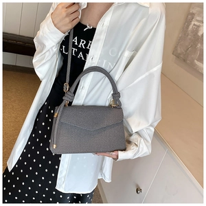 Detailed view of the grey textured envelope bag with gold hardware and stylish handle