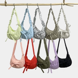 Detail of multi-color crescent shoulder bags with ruched straps and bow accents