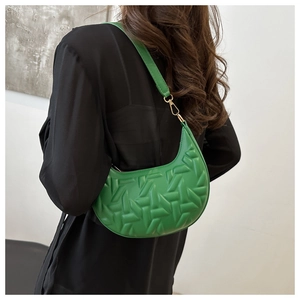 Detailed back view of green crescent shoulder bag with geometric embossed pattern and strap