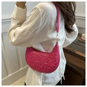 Detailed texture of magenta quilted hobo bag with gold metal hardware and slim strap