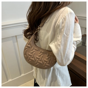 Detail of hobo bag with geometric embossed pattern and gold-tone metal hooks
