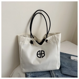 Detalle del bolso tote de lona blanca con logotipo BB negro y asas de cuerda
