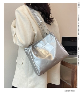 Detail of silver metallic tote bag with geometric stitching on a shoulder strap