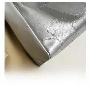 Detailed close-up of silver tote bag featuring high-quality pebble leather and precise stitching